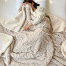 Soft double-sided lamb fleece and Tafu fleece jacquard blanket in solid colours folded on sofa