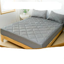 Gray mattress protector on a bed with text highlighting features and benefits.